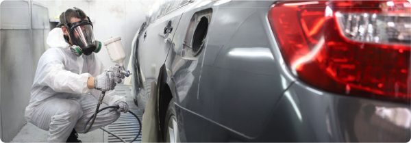 body shop technician painting grey car